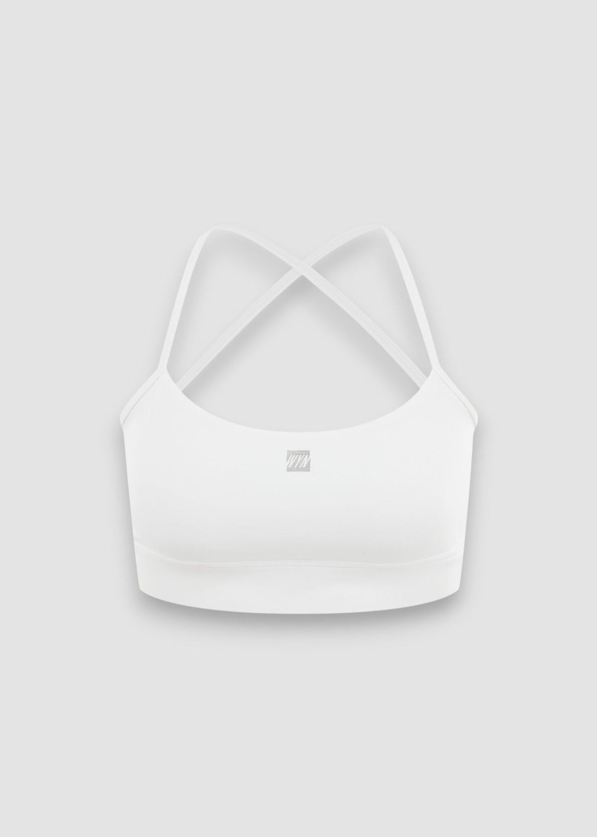 A white sports bra with thin crisscross back straps and a small square logo on the center front, displayed against a light gray background.